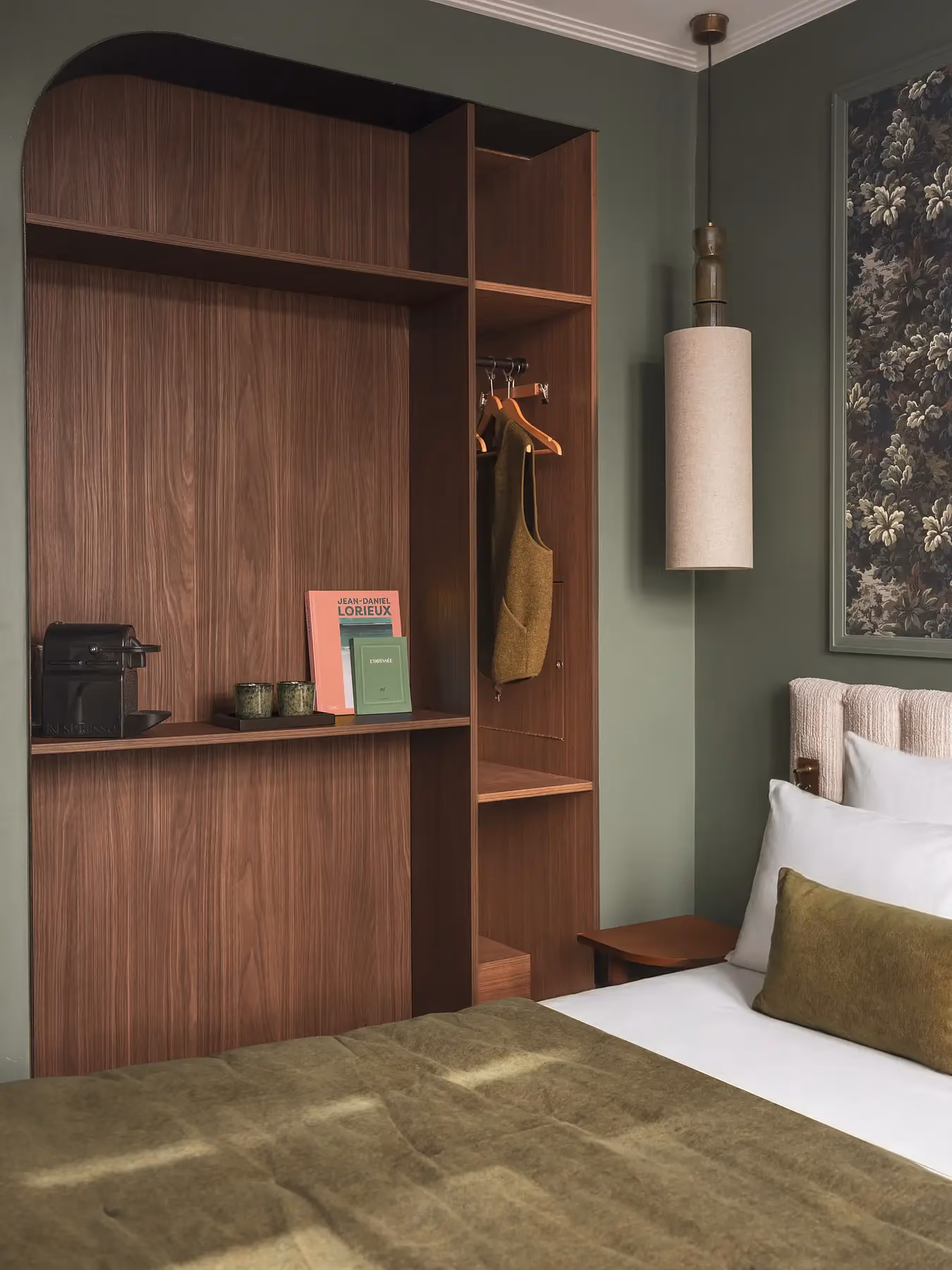 Rangement en bois voûté avec étagères, dans une chambre aux murs vert sauge.