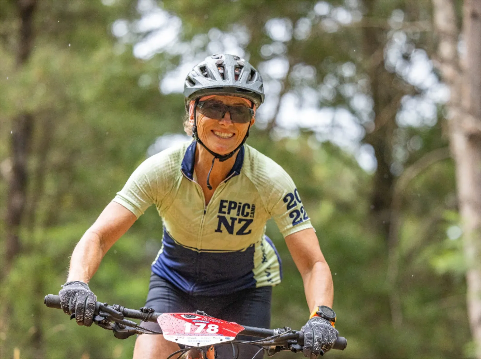 A lady riding a mountain bike and smiling