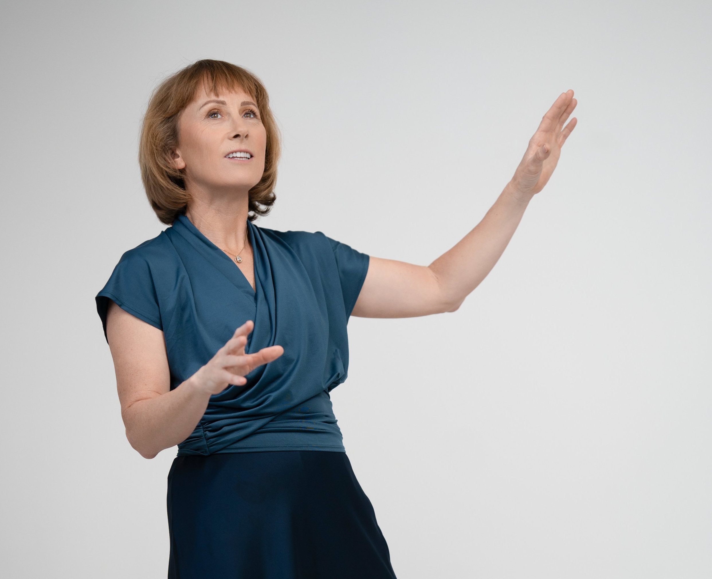 A smiling lady is talking with her hands up