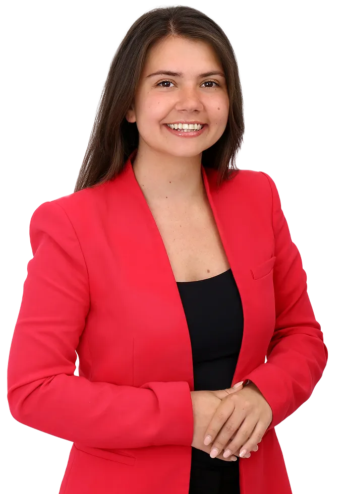 Smiling woman with long dark hair wearing a red blazer over a black top with hands clasped.