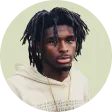 A man with dreadlocks wearing a white hoodie.