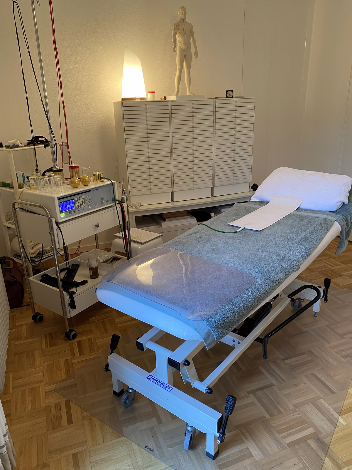 Behandlungsliege und Akupunktur-Modell