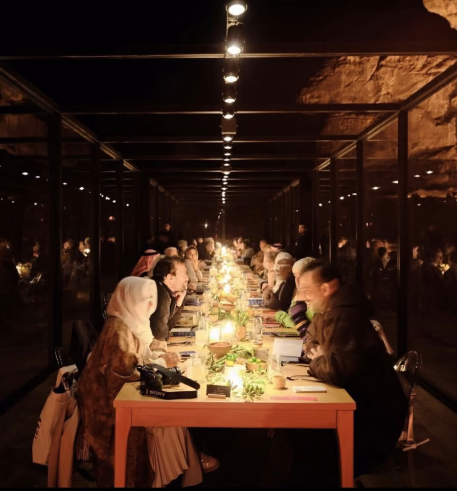 Long communal dinner table lit by candles at Wadi AlFann