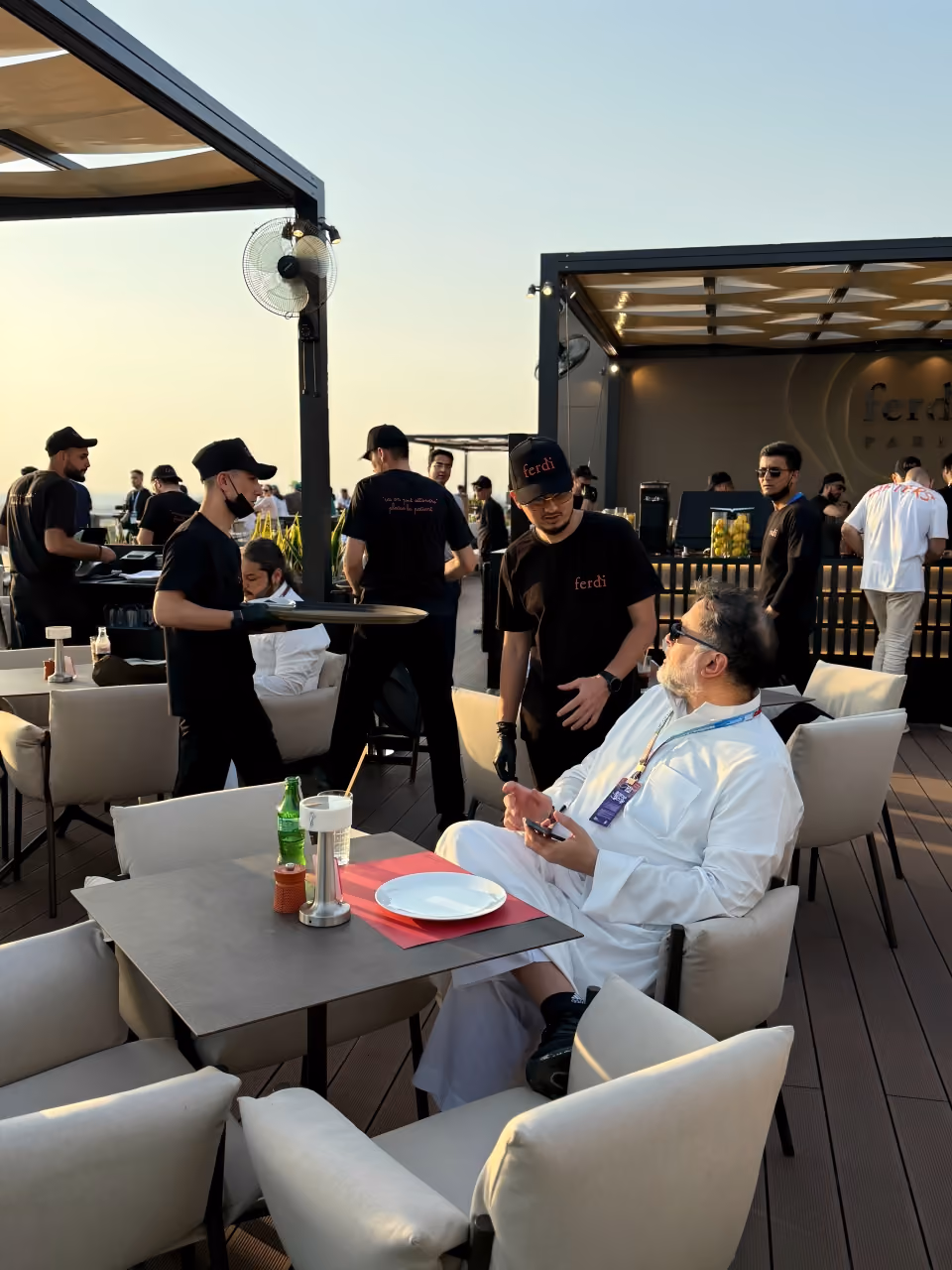 Ferdi service team working a rooftop terrace at dusk during an event