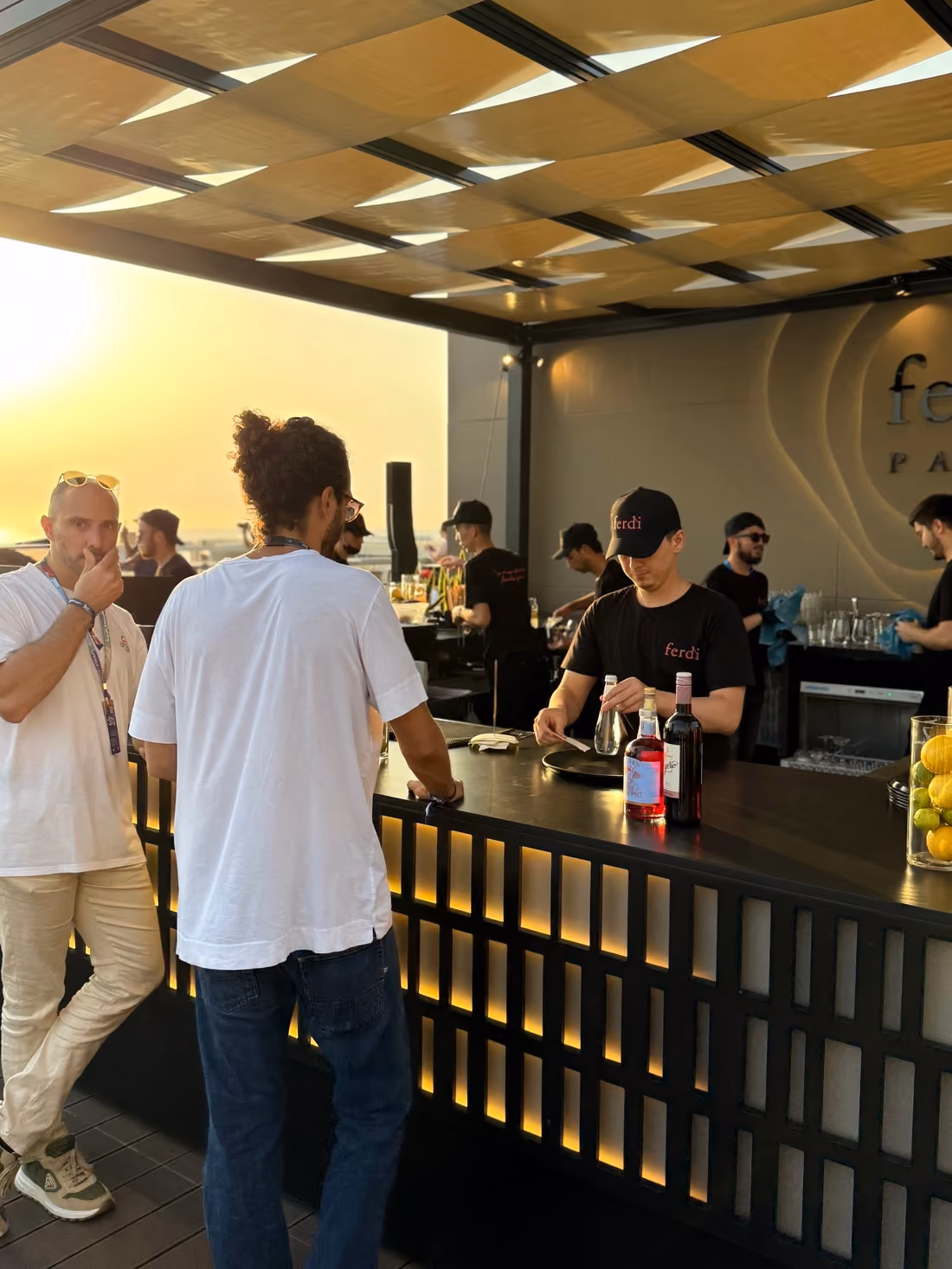 Waiter serving drinks to accredited guests on a rooftop hospitality deck