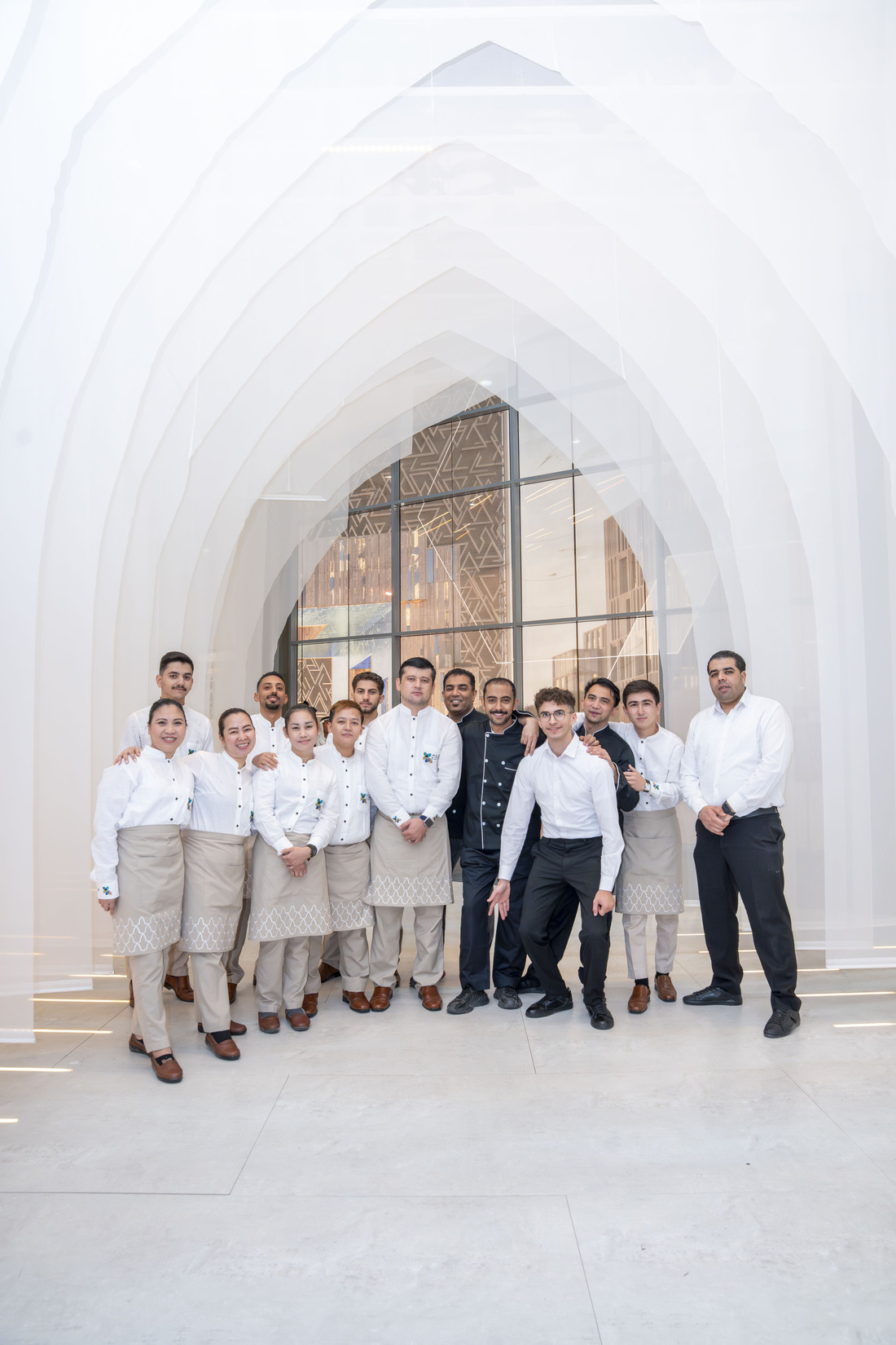 Melas service and kitchen team standing together against a timber wall