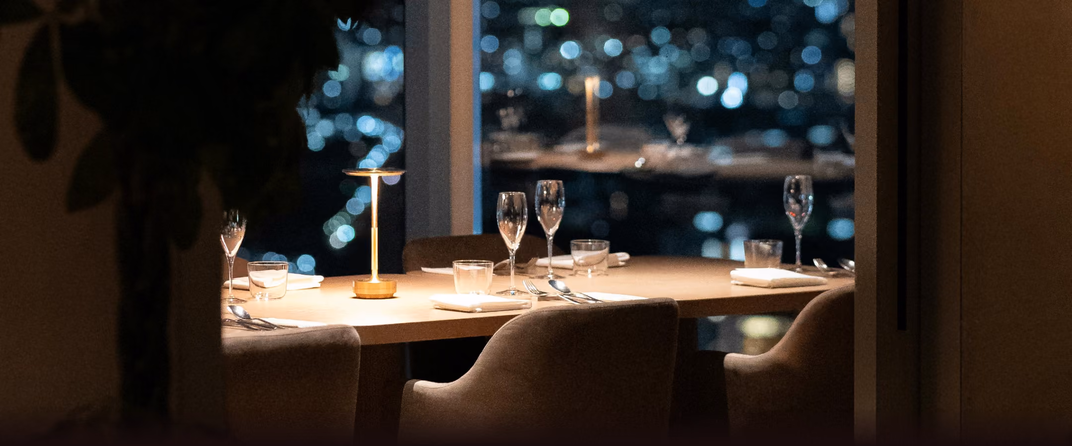 Set table by a window overlooking the city at night