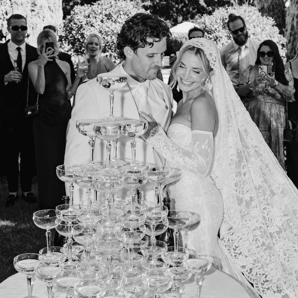 champagne tower at wedding, bride and groom smiling