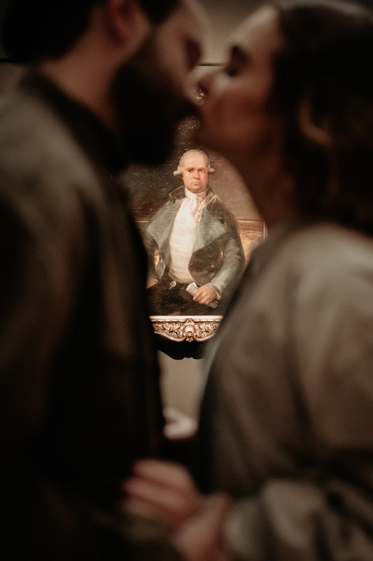 Detailfoto eines Gemäldes durch ein sich küssendes Paar durchfotografiert.