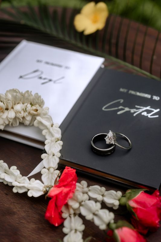 elopement vow books and rings between tropical flowers 