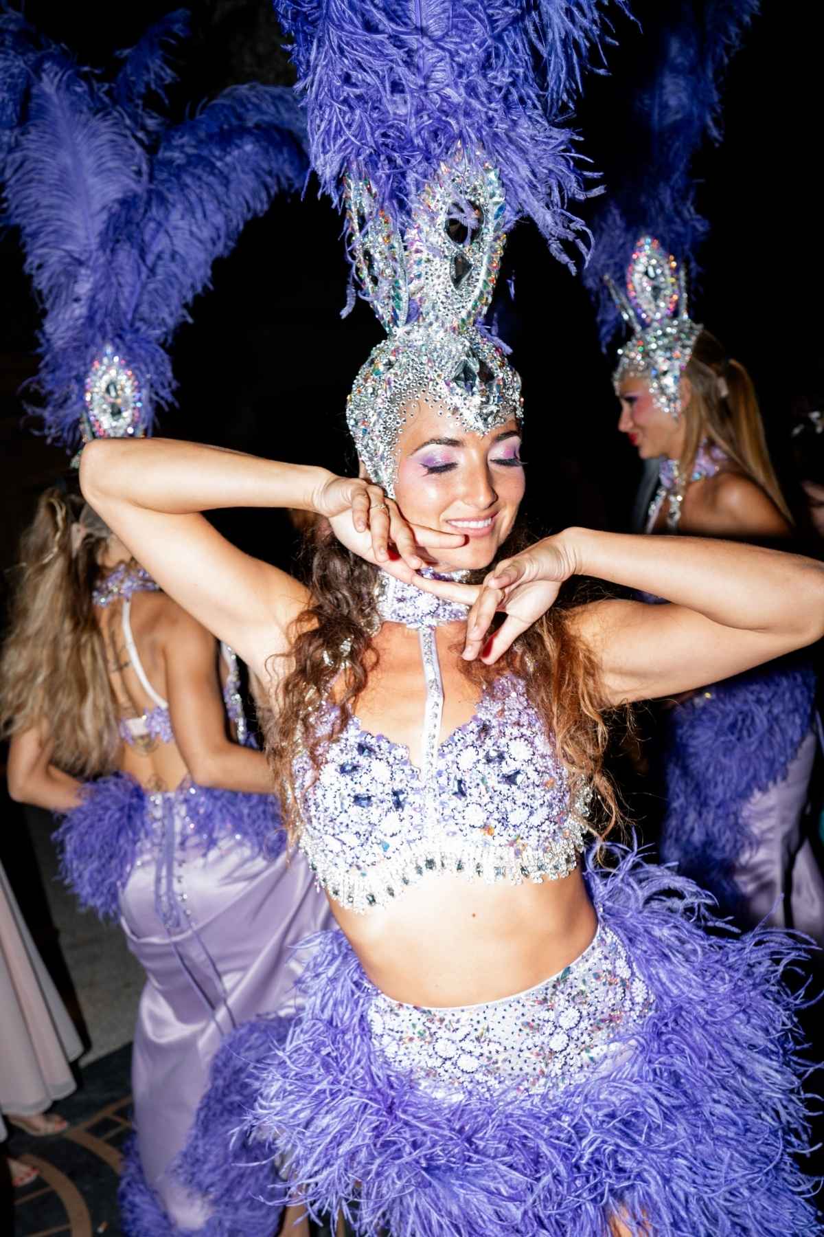 Showgirl performing in a feathered costume at a luxury wedding reception