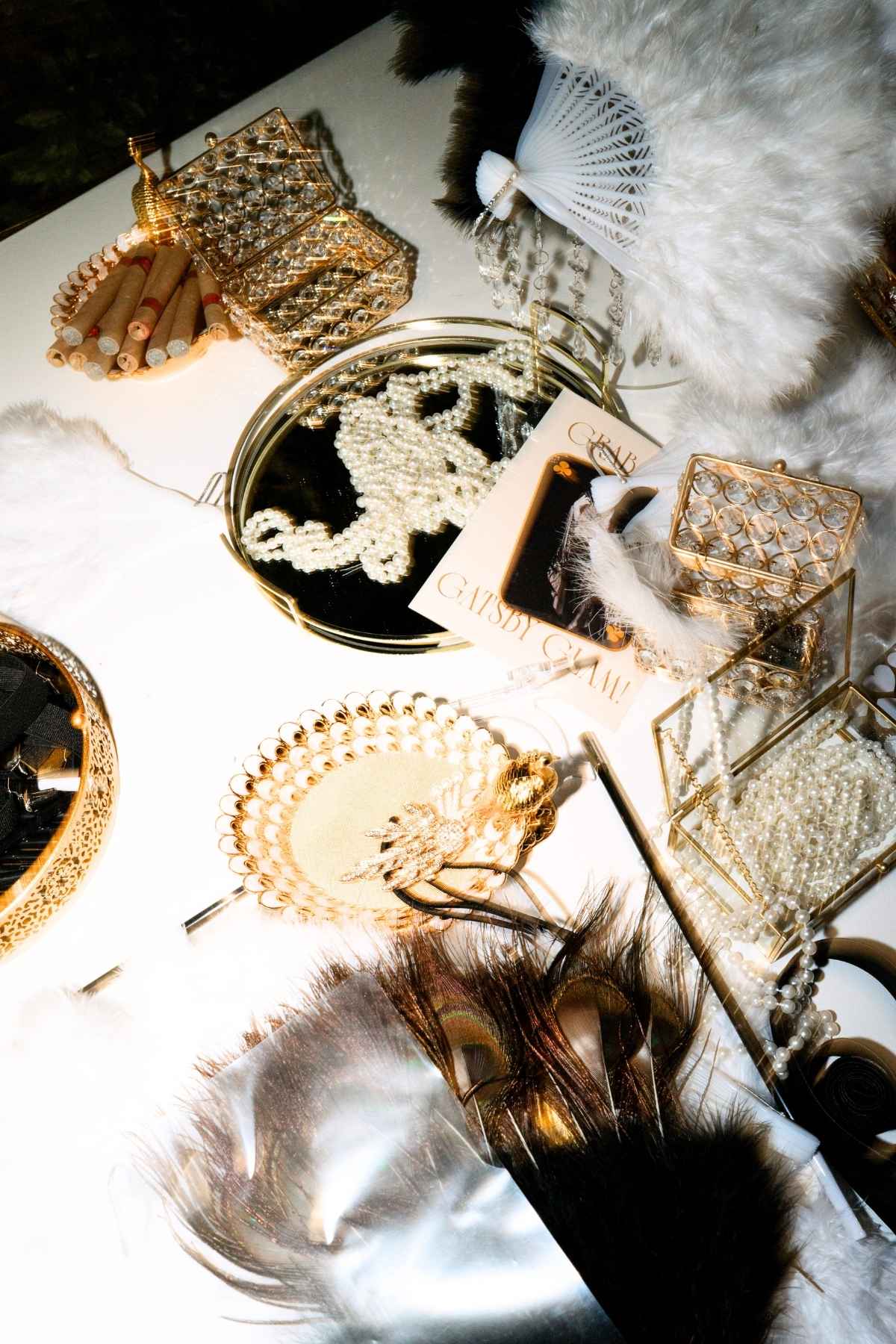 Editorial bridal details with pearls, feather fans and gold Art Deco accessories