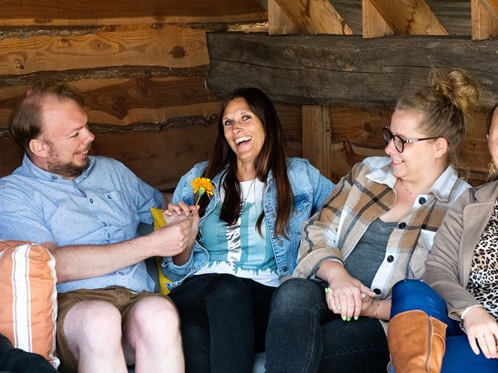 Telsmart colleagues laughing together on a bench during a team day