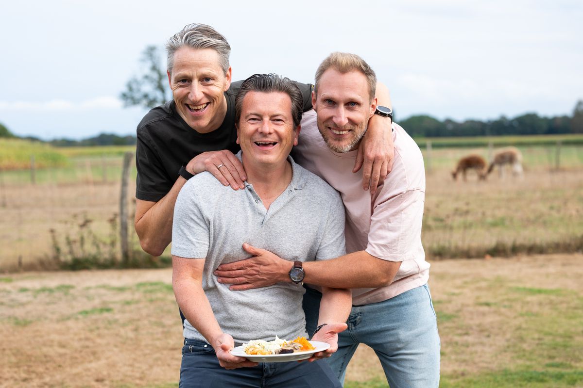 Three Telsmart colleagues with their arms around each other, one holding a plate of food
