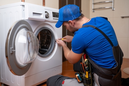 Professional technician carrying out appliance repairs on a washing machine in Bristol.