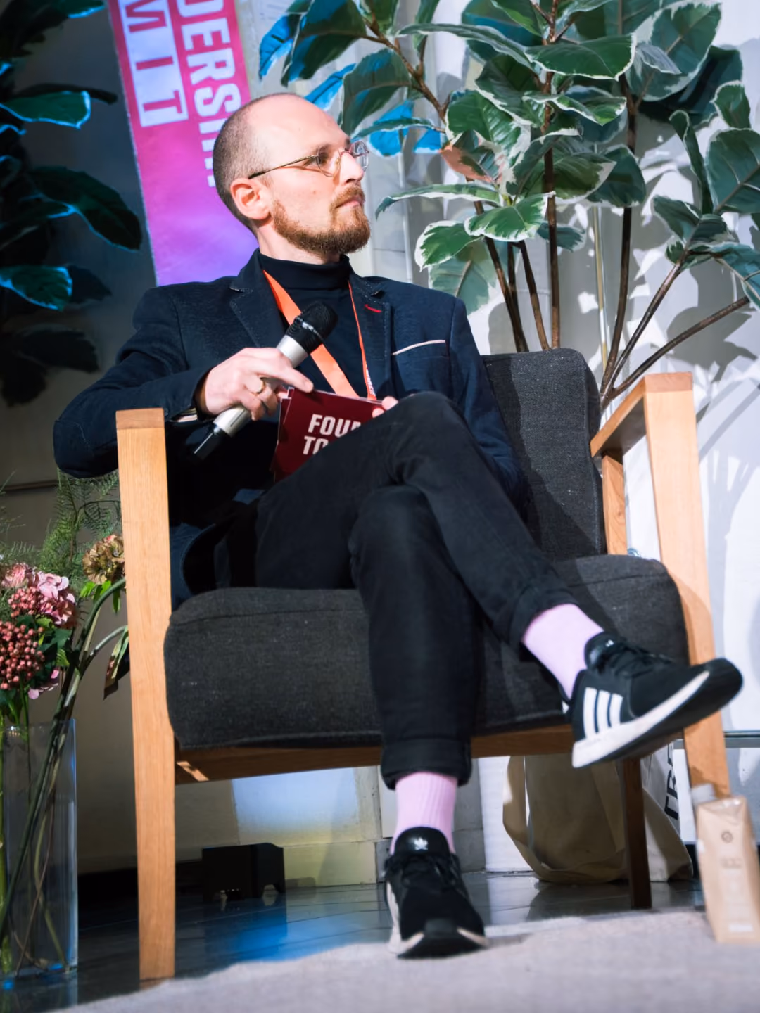 Fredo CEO Mads Kjer on stage, holding a microphone.