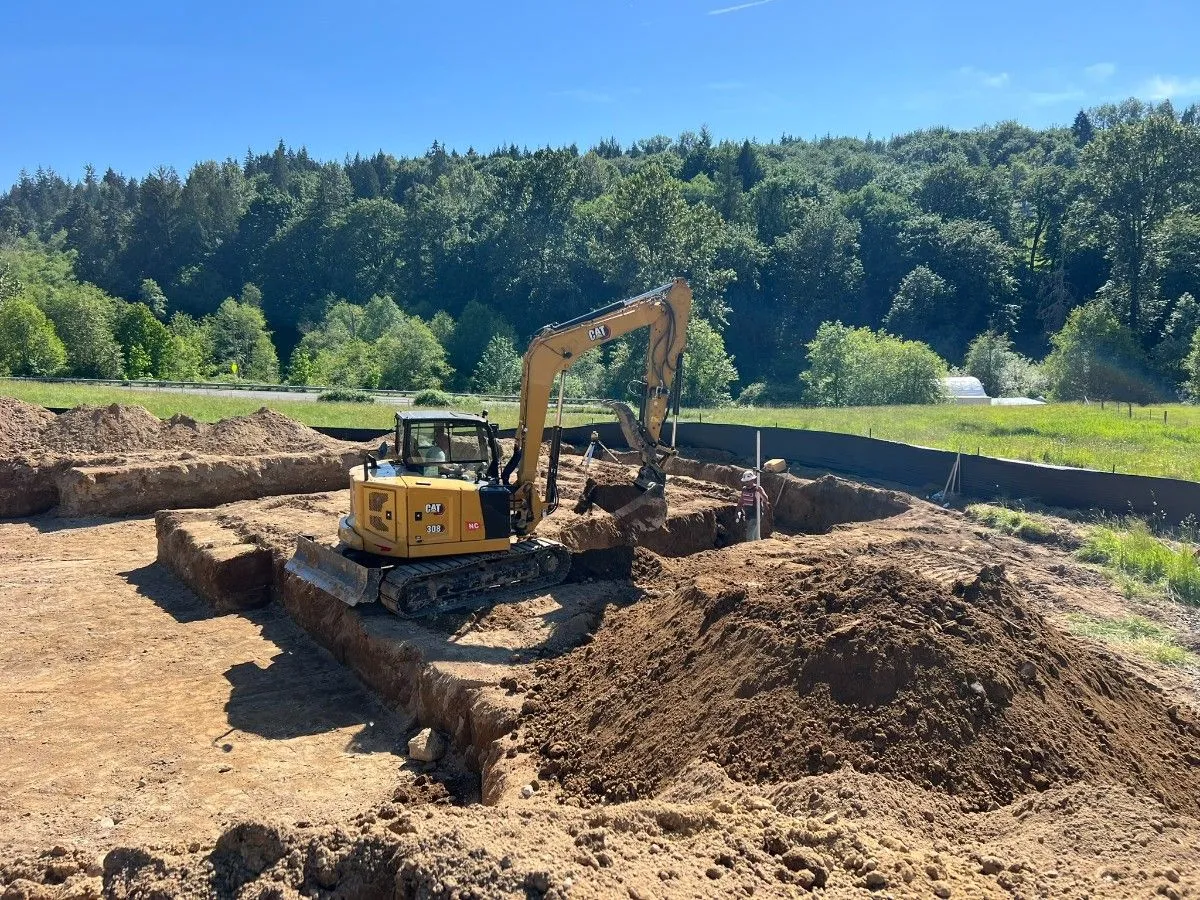 An excavator near a pile of soil excavated in an empty property in Seattle