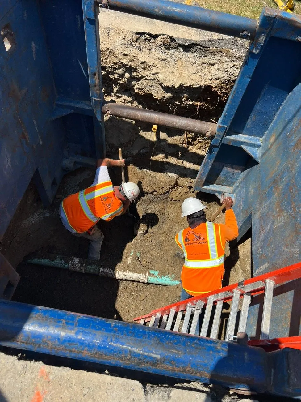 Excavation contractor digging on an excavated road for sewer installation in Seattle