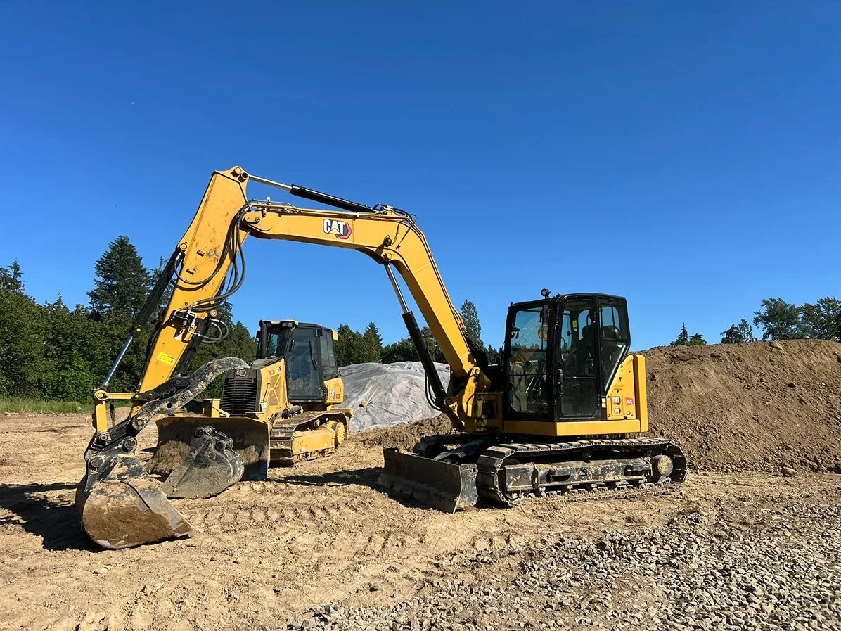 A Caterpillar excavator in a job site cleared from grass and trees in Seattle
