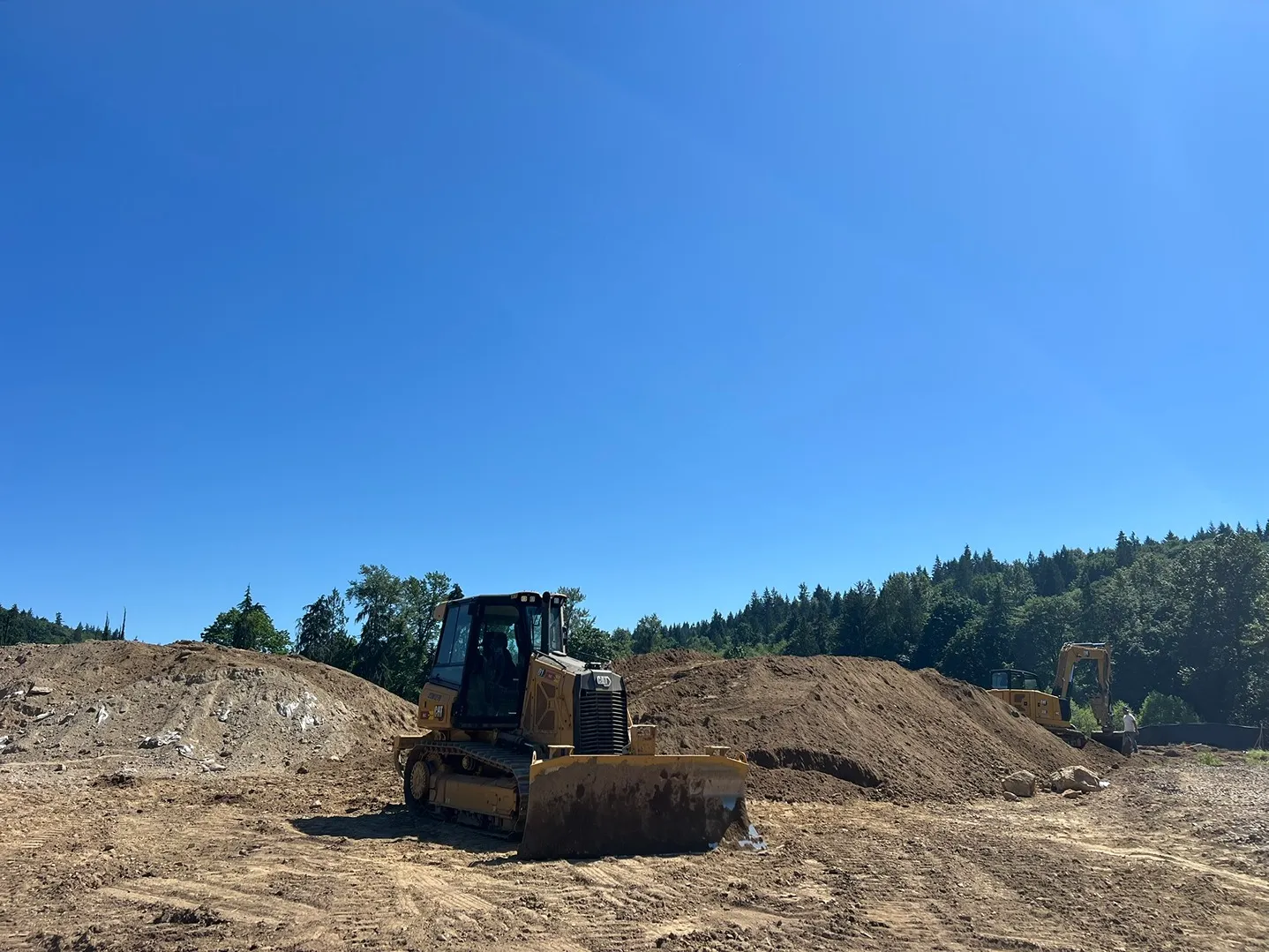 A bulldozer parked beside piles of soil in a construction site in Seattle