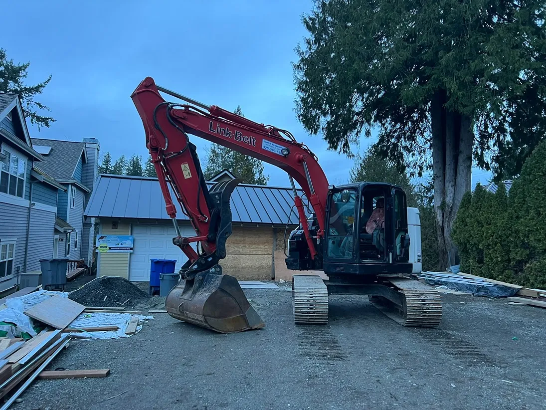 A Link-Belt excavator parked near a home to be demolished in Seattle