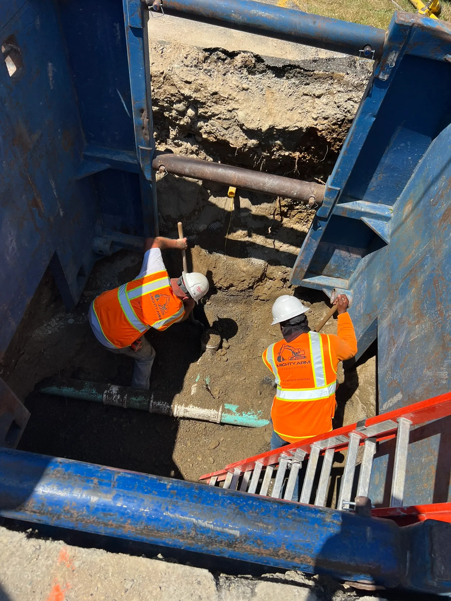 Two contractor digging a hole for sewer line installation in Seattle