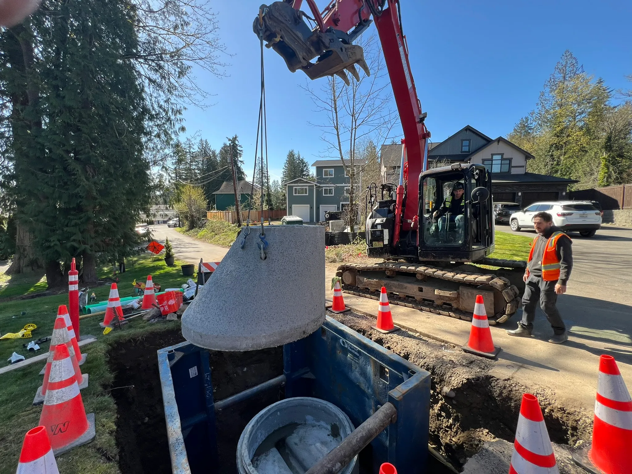 Contractors setting a precast detention vault on a commercial site near Tacoma