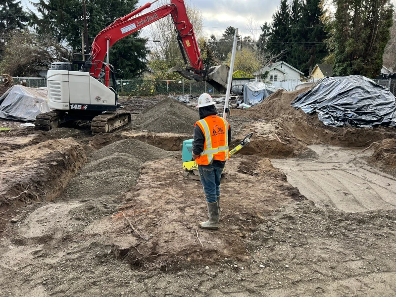 worker by mini excavator pit