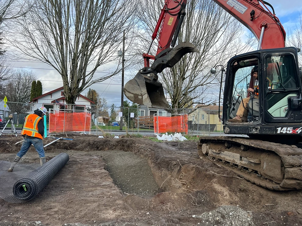 An excavator digging a trench for utility installation in Seattle