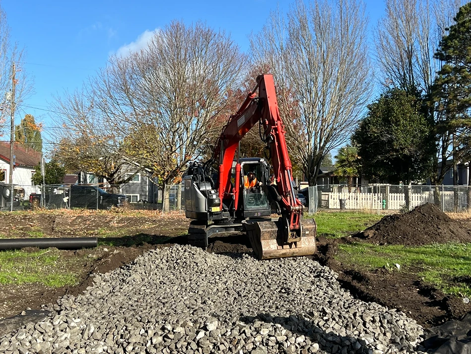 An excavator adding gravel for foundation of a home in Seattle