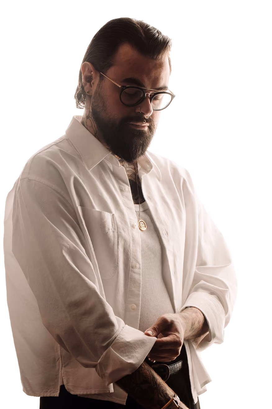 Nick Reed, tattoo artist at Sonder Tattoo & Piercing London, in a white shirt with tattooed hands and neck.