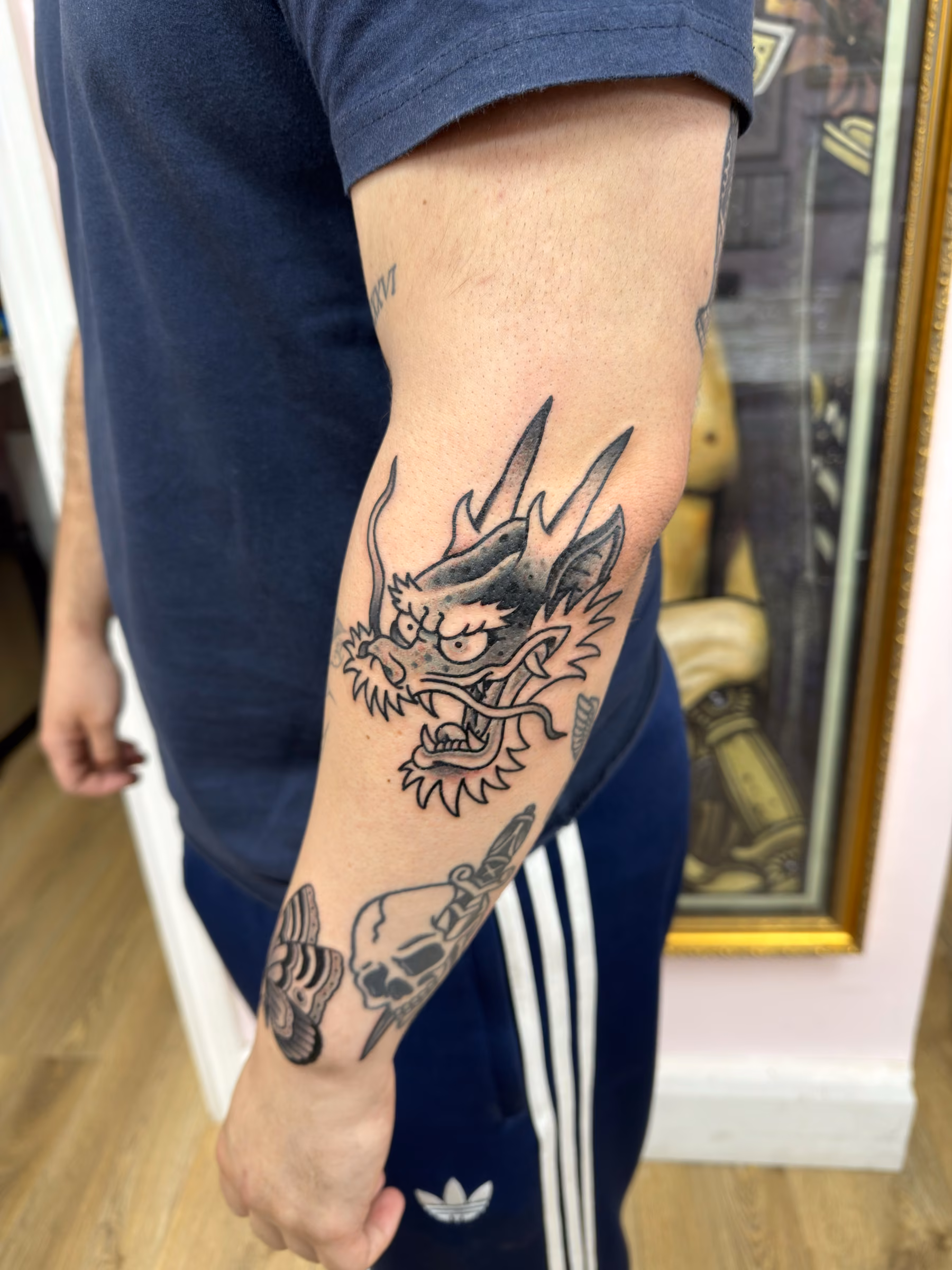 Traditional Japanese dragon head tattoo on an elbow