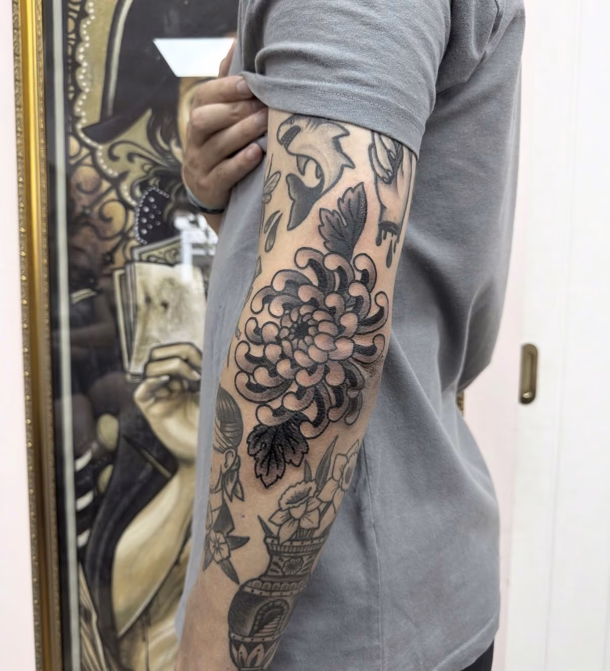 Traditional chrysanthemum tattoo sleeve on an upper arm