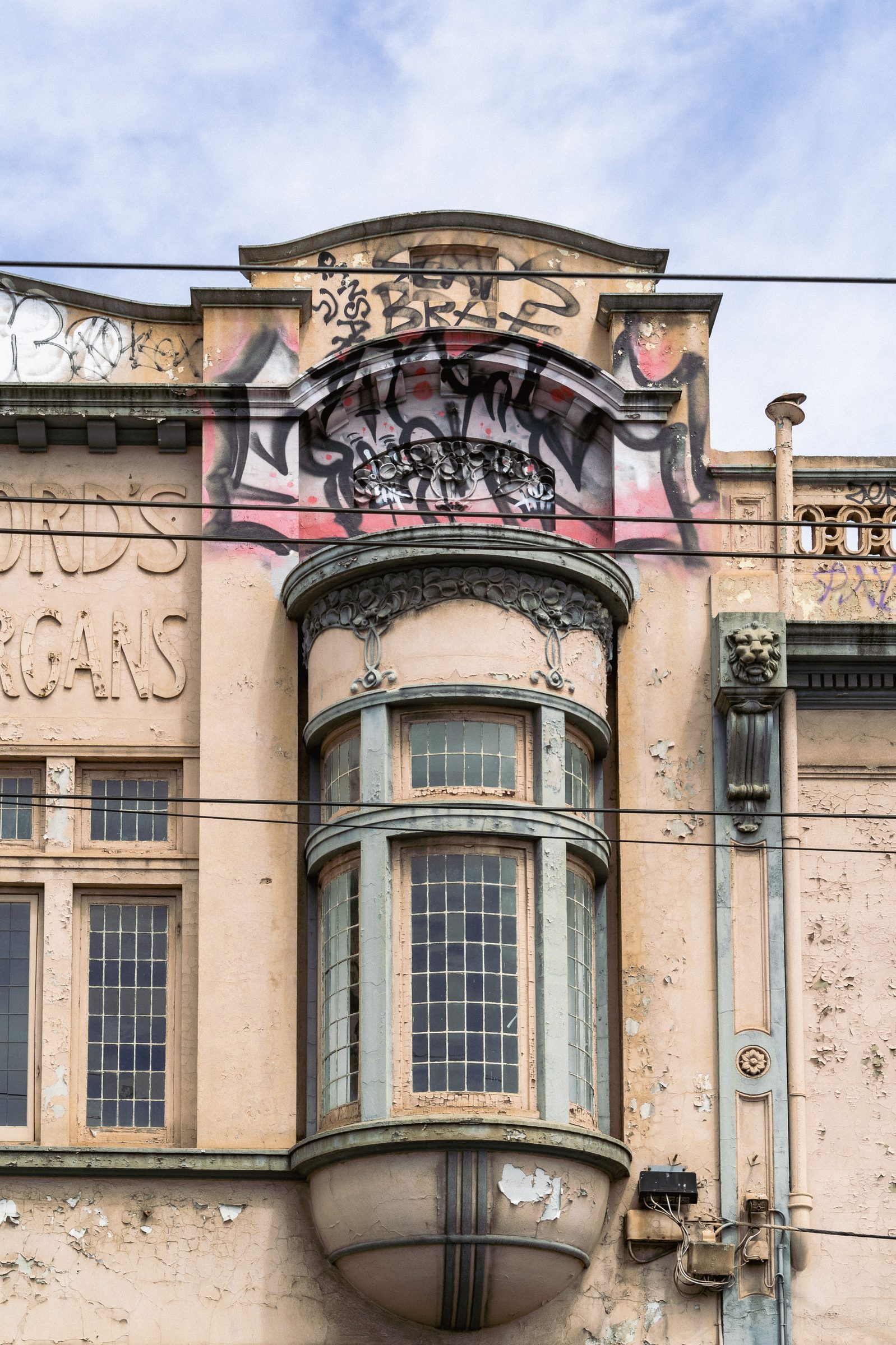 Ornate art deco building facade with layered graffiti, Melbourne inner north