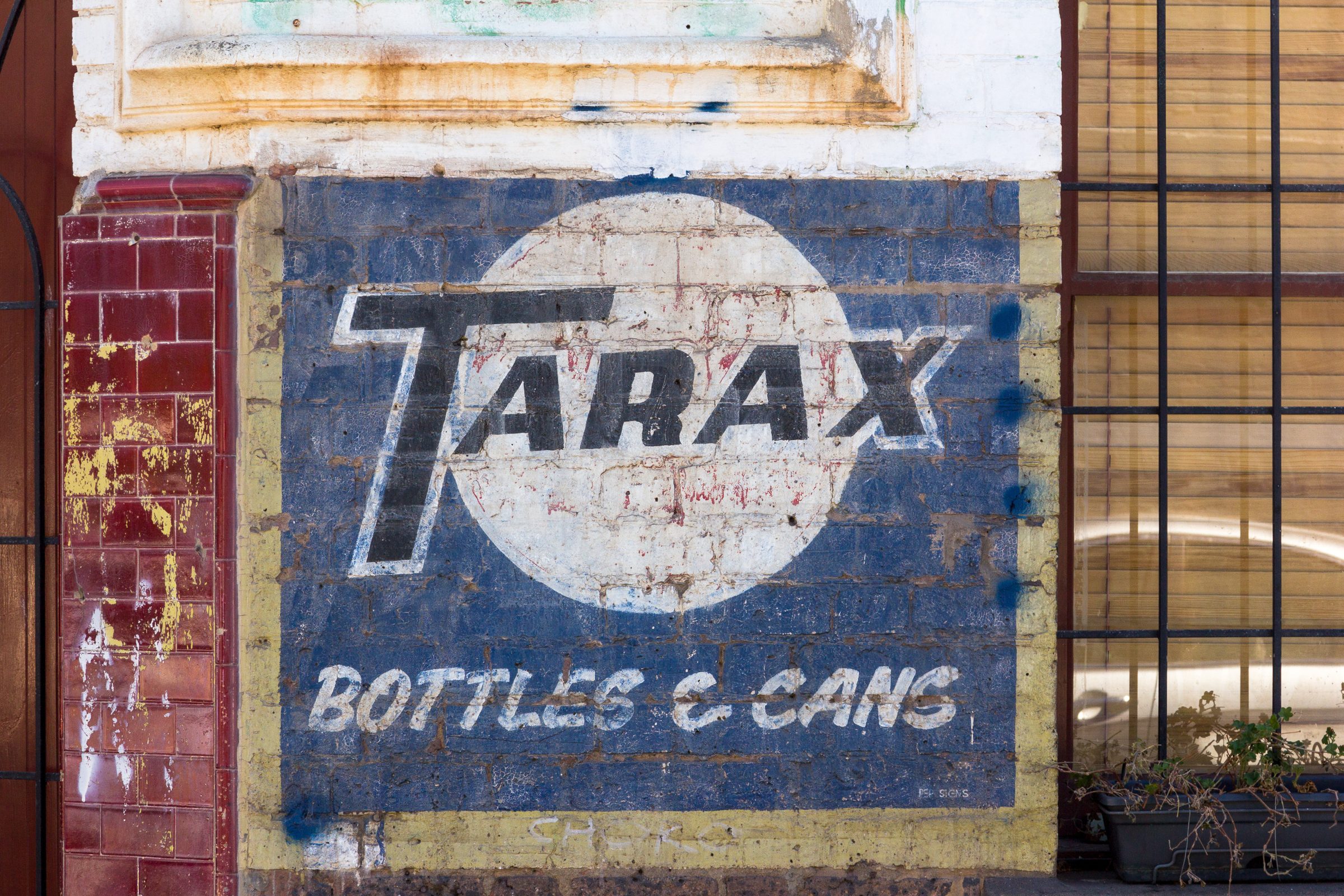 Faded Tarax ghost sign painted on a Melbourne shopfront wall