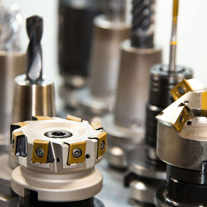Verschiedene metallische Schneidwerkzeuge mit goldenen Einsätzen für die industrielle Fertigung.