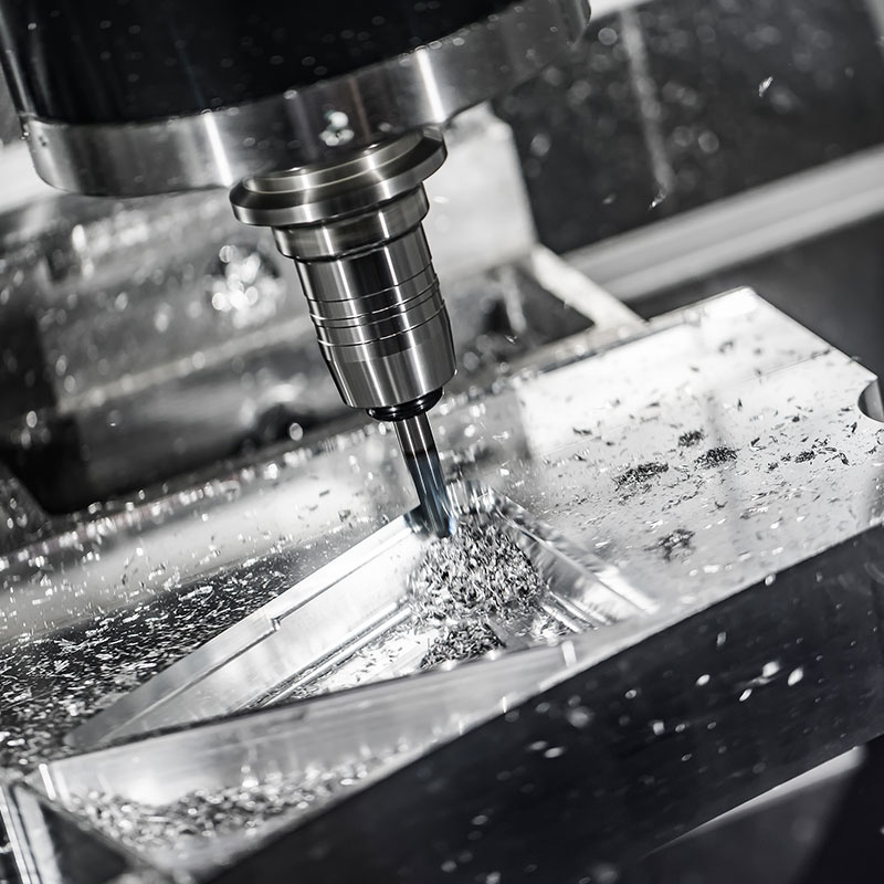 CNC-Fräsmaschine, die Metall bearbeitet, wobei Späne und Funken fliegen.