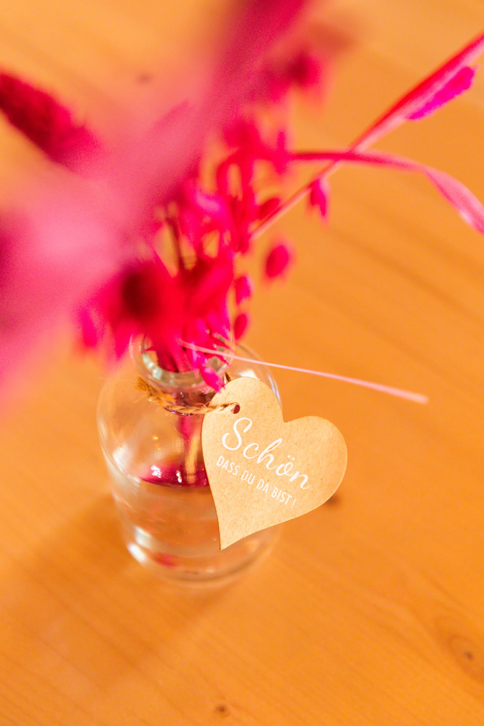 Pinke Blume mit Herz-Anhänger in einer Vase – Tischdeko im Uferstüble