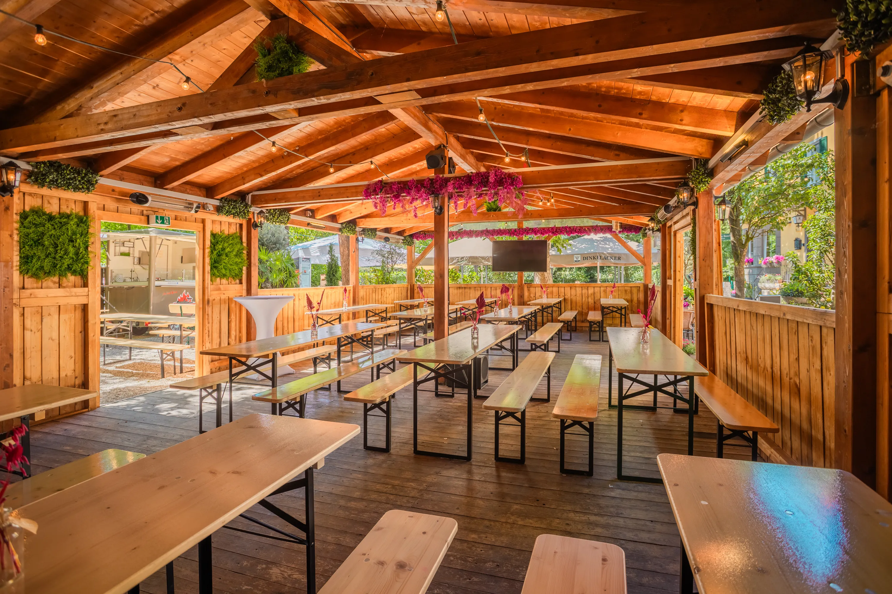 Uferlounge mit Holzbänken und Blumendeko, vorbereitet für eine Feier