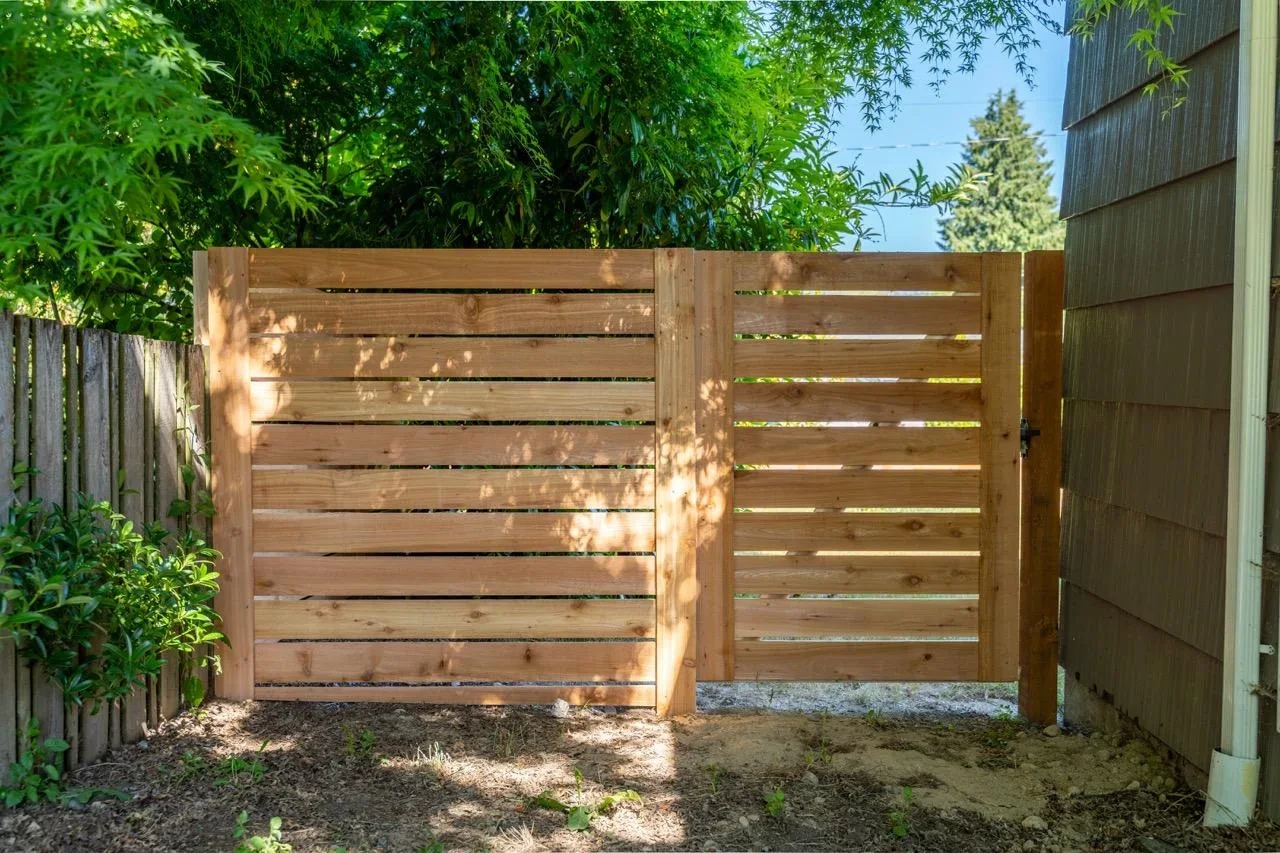 Homeowner standing beside their new fence