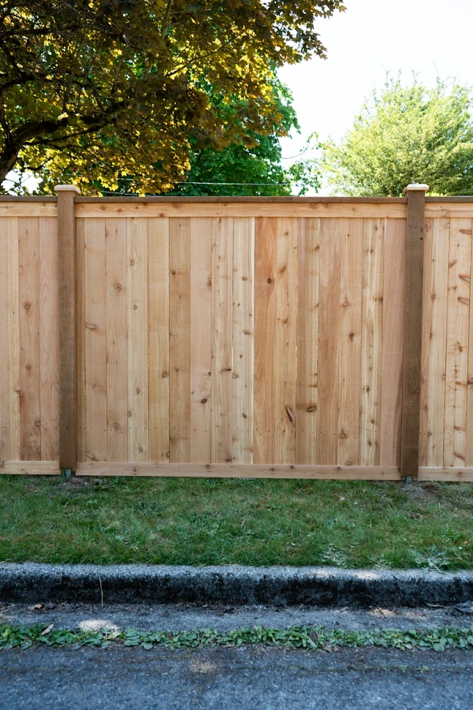Fence contractor measuring a backyard lot in Orchards