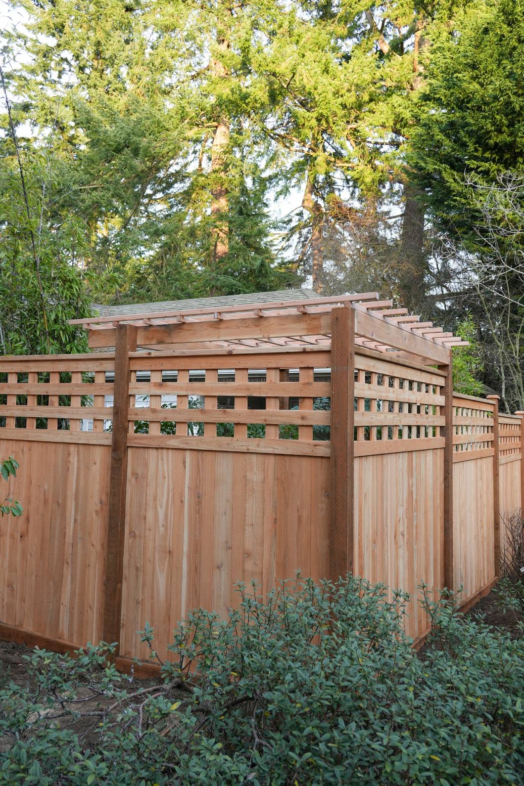 Wooden fence with a small pergola in the corner of a Battle Ground backyard