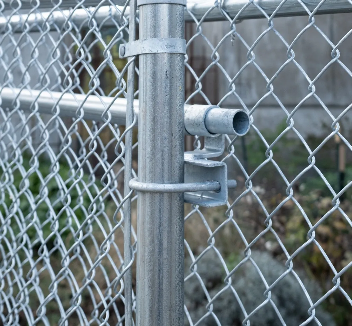 Galvanized chain link fence post with barbed wire in a Vancouver property