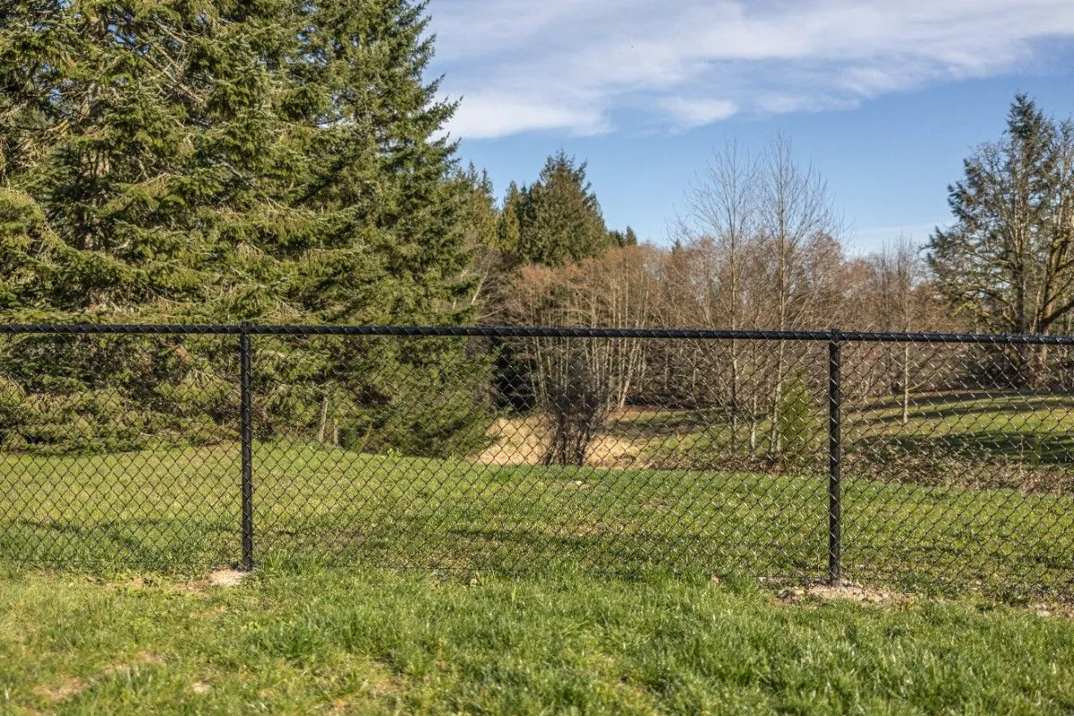 Black chain link fence with posts set deep in the ground in a Portland property