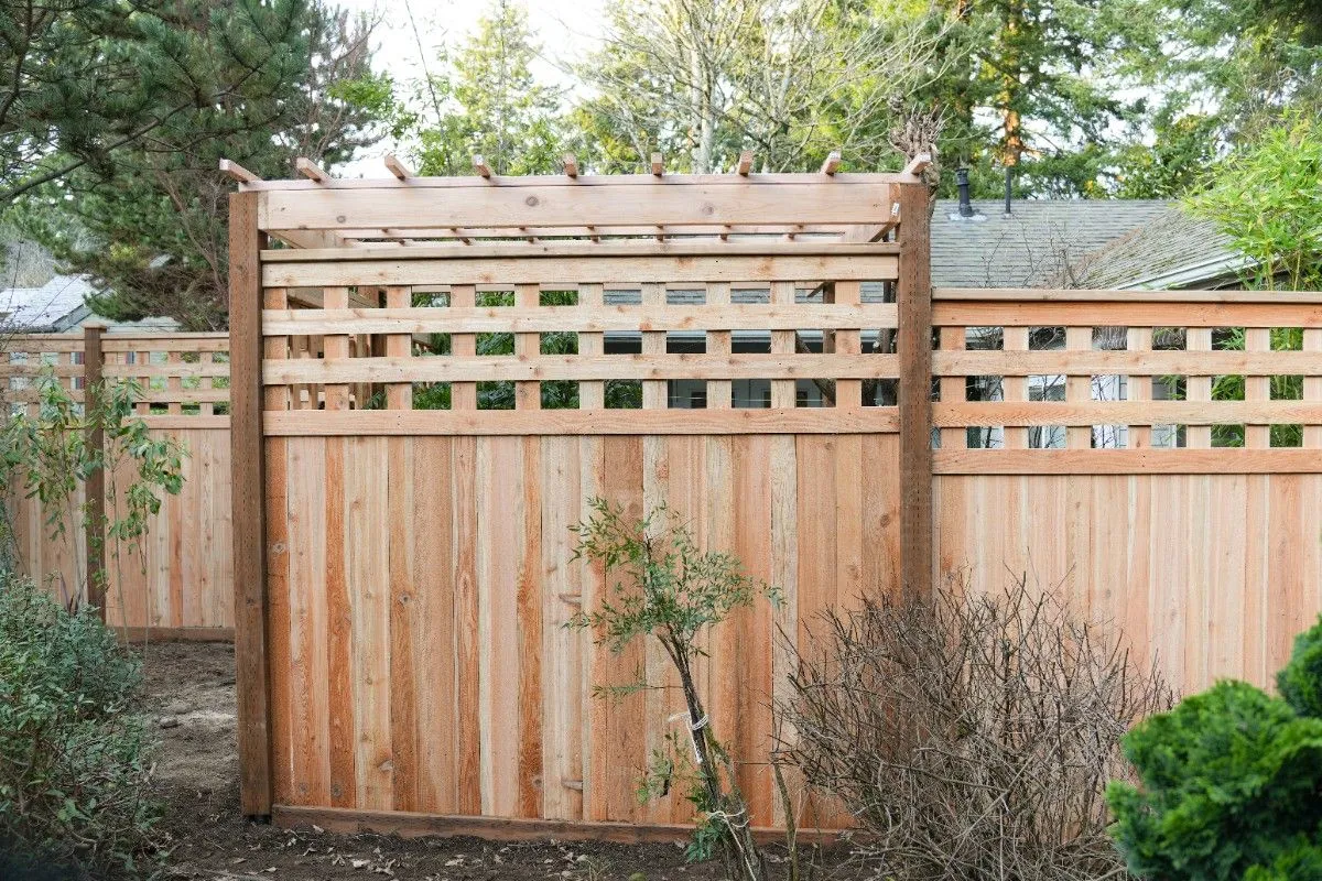 A backyard wooden fence with small pergola in a remote SW Washington property