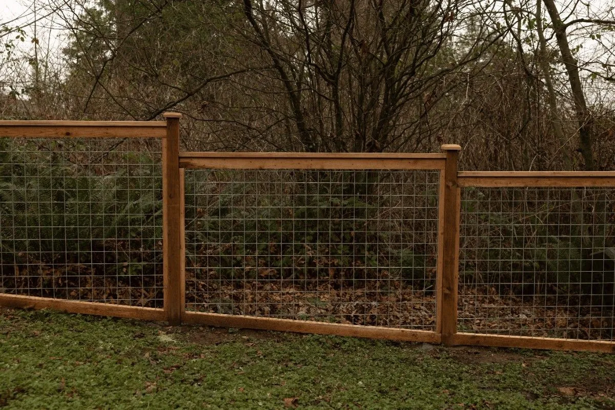 Hog wire fence with wooden frame built on a sloped lot in SW Washington
