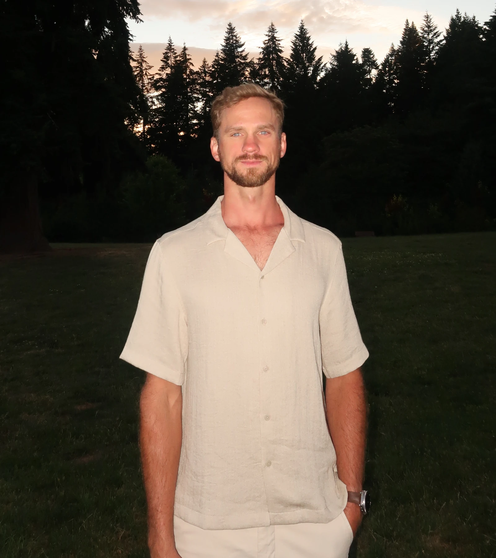 Portrait of the owner of Terek Fencing standing outdoors at sunset among evergreen trees