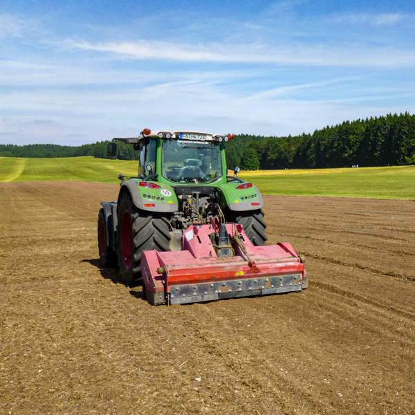 Traktor mit Steinbrecher auf einem Acker