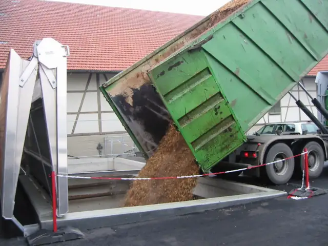 Lkw kippt Hackschnitzel in den Bunker einer Hackschnitzelheizung