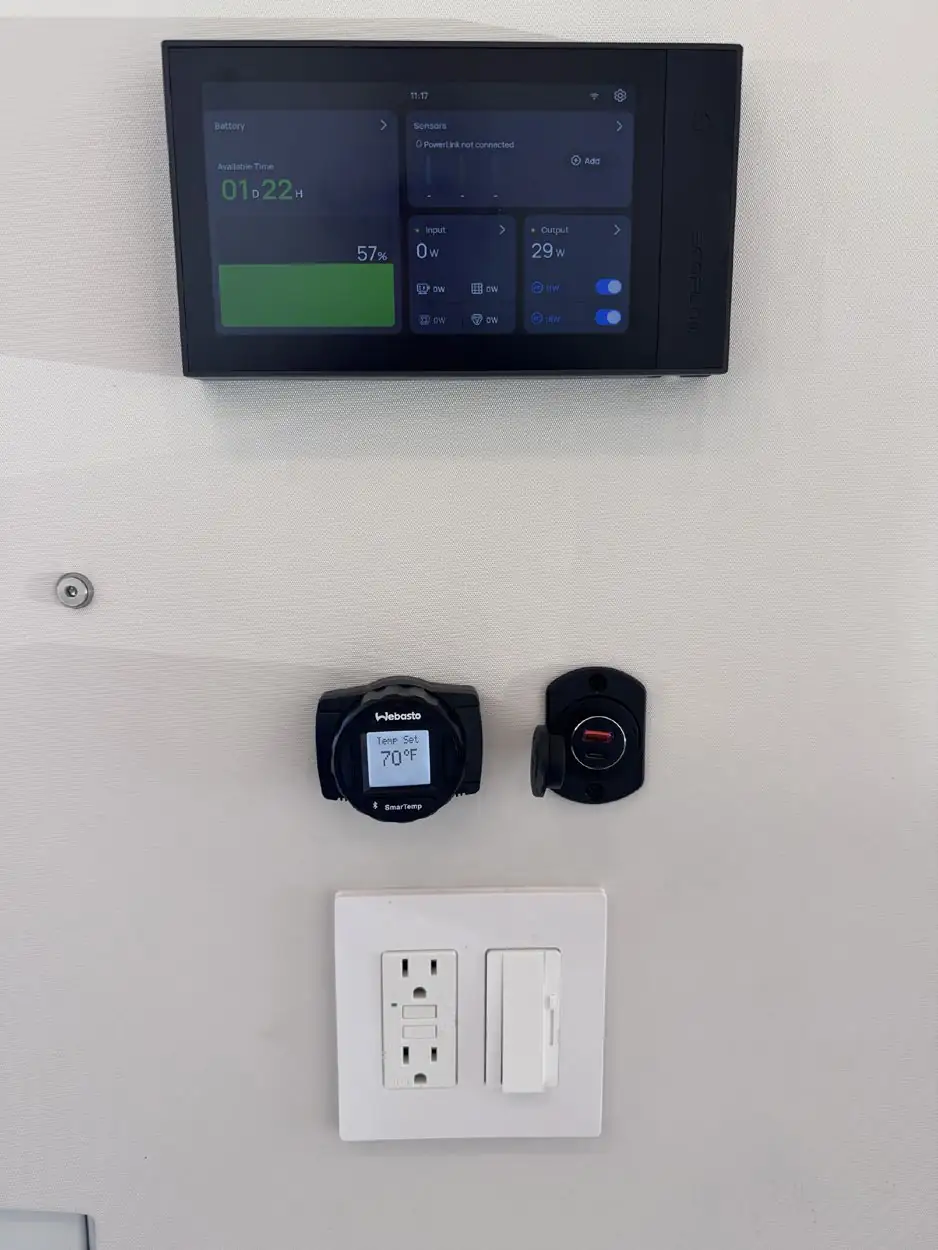Wall panel with EcoFlow touchscreen, Webasto thermostat reading 70°F, USB port, outlet and dimmer inside a van